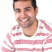 Portrait of young Asian man smiling at camera.